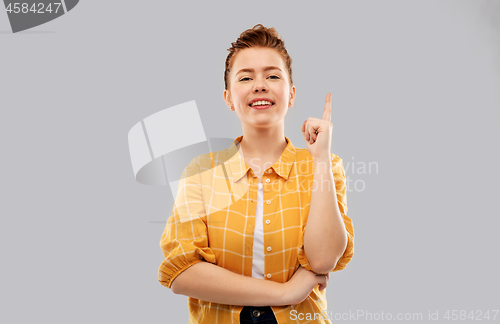 Image of red haired teenage girl pointing finger up