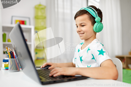 Image of boy in headphones playing video game on laptop