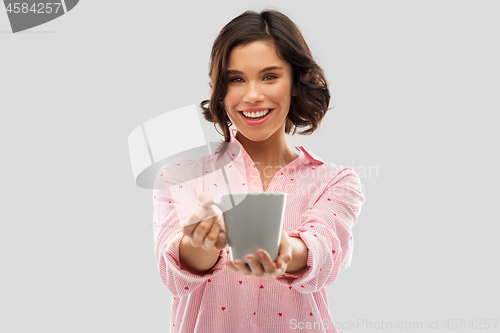 Image of happy young woman in pajama with mug of coffee