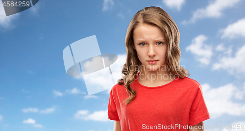 Image of sad or angry teenage girl in red t-shirt over sky