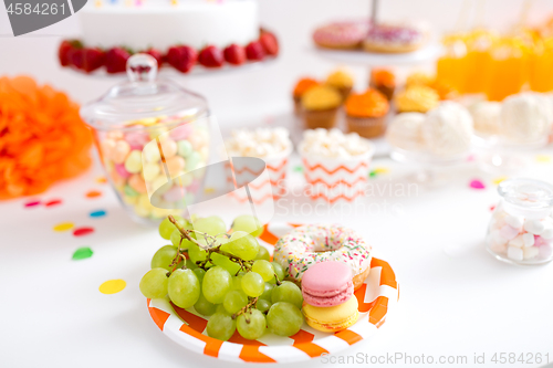 Image of grapes, macarons and donut on party table