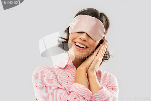 Image of happy young woman in pajama and eye sleeping mask