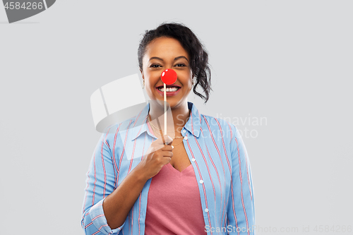 Image of happy african american woman with red clown nose