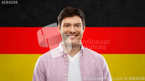 Image of smiling young man over german flag colors