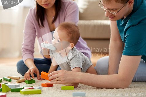 Image of happy family with baby boy playing at home
