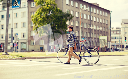 Image of young man with fixed gear bicycle on crosswalk