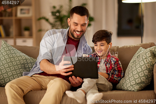 Image of father and son listening to music on tablet pc