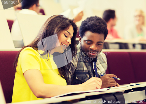 Image of group of students with notebooks in lecture hall