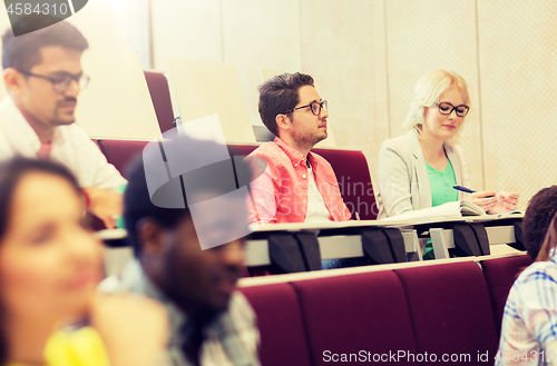 Image of group of students with notebooks in lecture hall