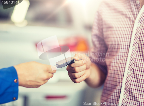 Image of auto mechanic giving car key to man at workshop