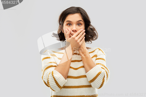 Image of shocked young woman covering her mouth by hands