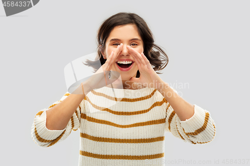 Image of happy woman in striped pullover calling someone