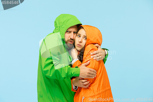 Image of The young couplel posing at studio in autumn jackets isolated on blue