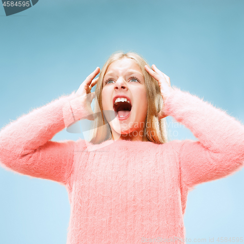 Image of Isolated on blue young casual teen girl shouting at studio