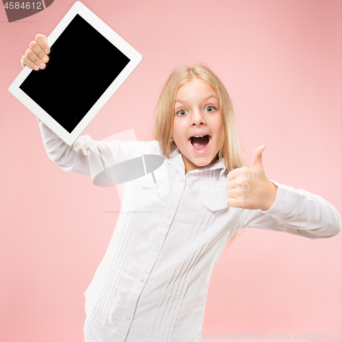 Image of Little funny girl with tablet on pink background