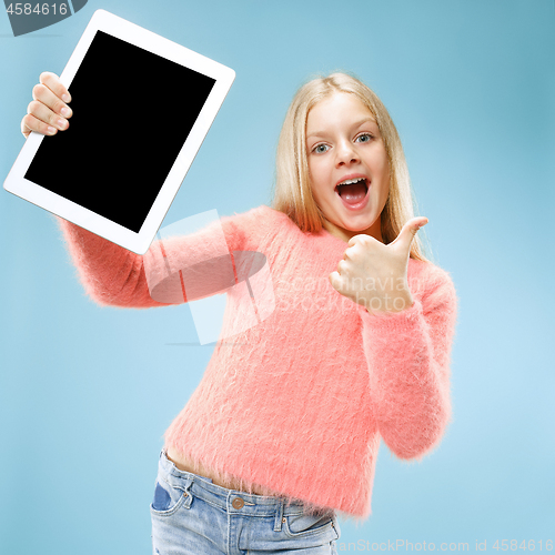 Image of Little funny girl with tablet on blue background