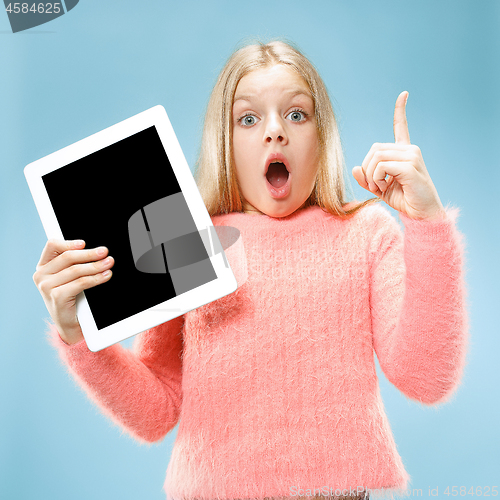 Image of Little funny girl with tablet on blue background