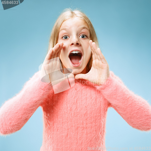 Image of Isolated on blue young casual teen girl shouting at studio