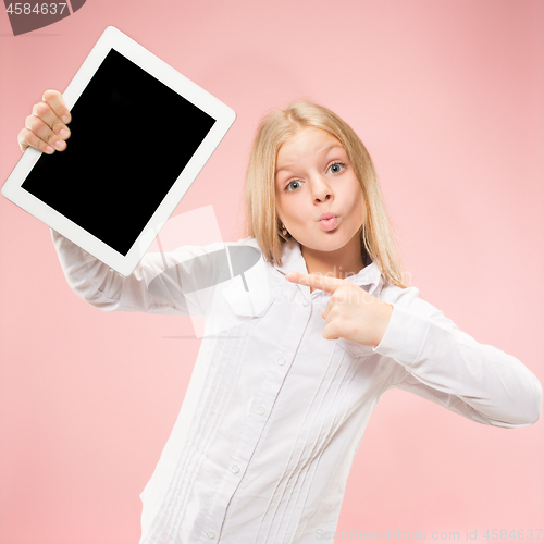 Image of Little funny girl with tablet on pink background