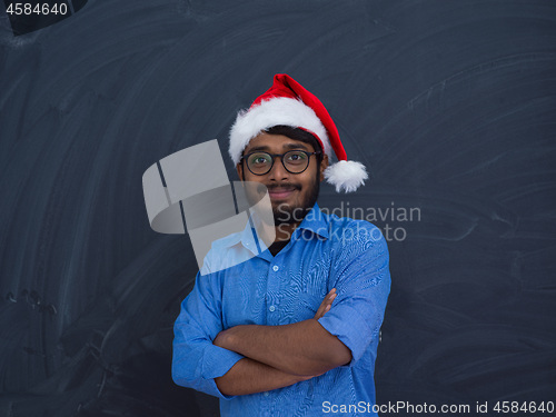 Image of Indian man wearing traditional Santa Claus hat