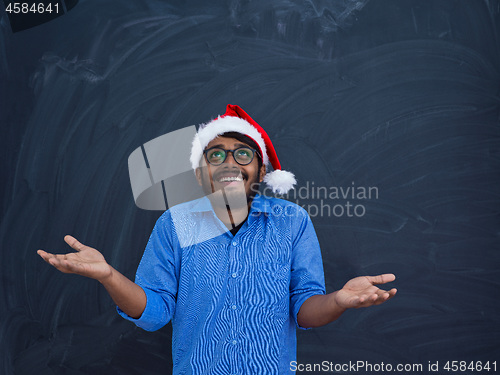 Image of Indian man wearing traditional Santa Claus hat