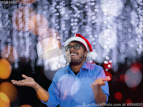 Image of Indian man wearing traditional Santa Claus hat