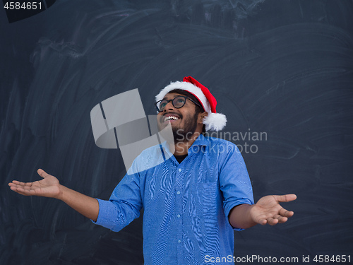 Image of Indian man wearing traditional Santa Claus hat