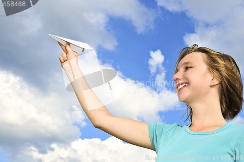 Image of Young girl holding paper airplane