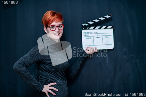 Image of redhead woman holding movie clapper