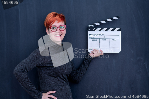 Image of redhead woman holding movie clapper