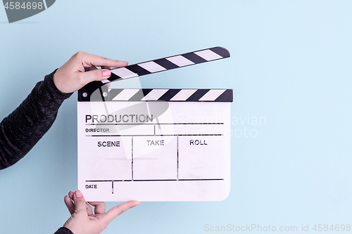 Image of movie clapper isolated on cyan background