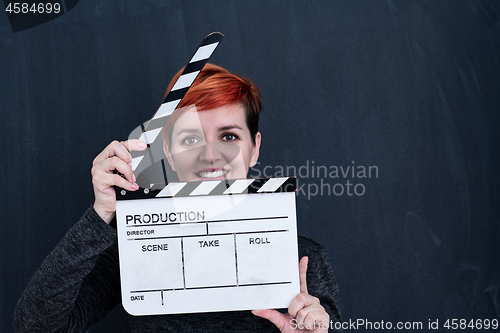 Image of redhead woman holding movie clapper