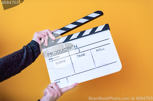 Image of movie clapper isolated on yellow background