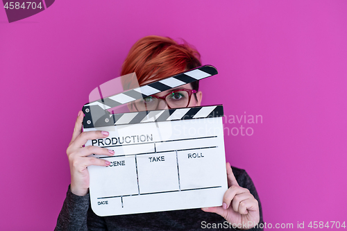 Image of woman holding movie clapper isolated on pink background