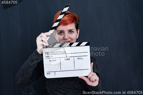 Image of redhead woman holding movie clapper