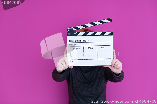 Image of woman holding movie clapper isolated on pink background