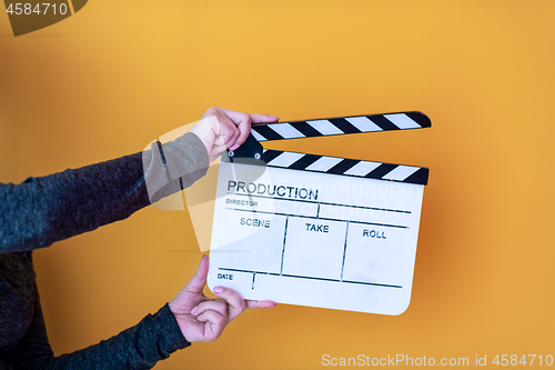 Image of movie clapper isolated on yellow background