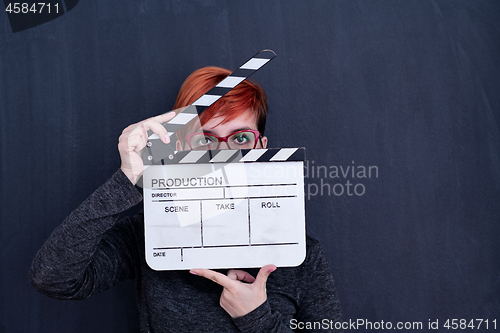 Image of redhead woman holding movie clapper