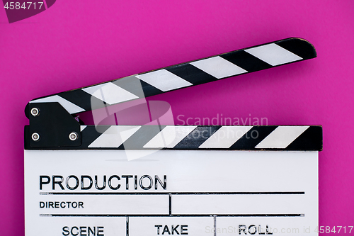 Image of movie clapper on pink purple violet background