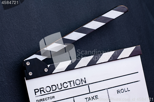 Image of movie clapper on black chalkboard background