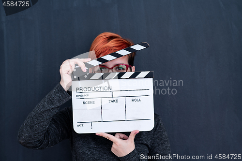 Image of redhead woman holding movie clapper