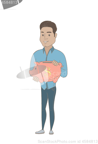 Image of Young hispanic businessman holding a piggy bank.
