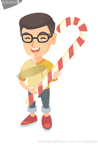 Image of Caucasian little boy holding christmas candy cane.
