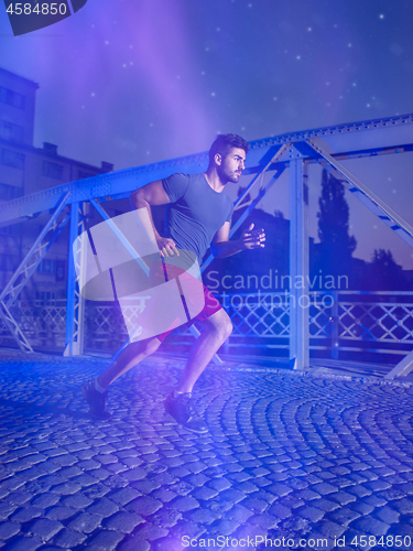 Image of man jogging across the bridge in the city