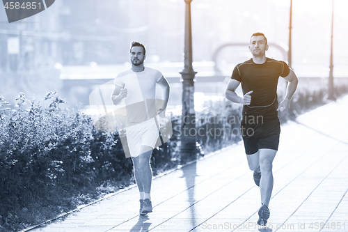 Image of group of young people jogging in the city