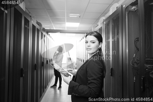 Image of Female engineer working on a tablet computer in server room