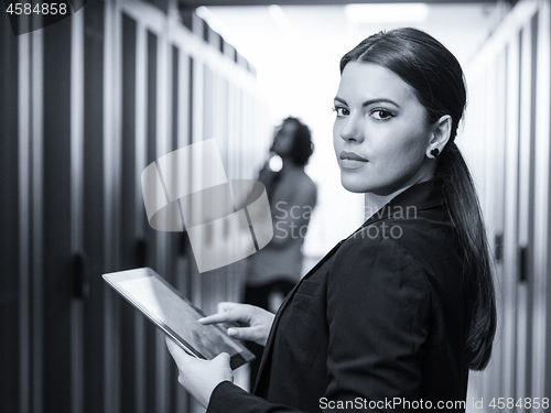 Image of Female engineer working on a tablet computer in server room