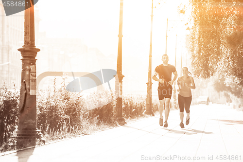 Image of young couple jogging  in the city