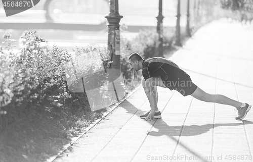 Image of athlete man warming up and stretching