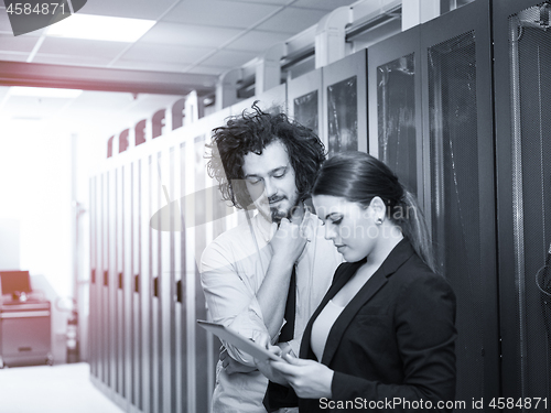 Image of engineer showing working data center server room to female chief